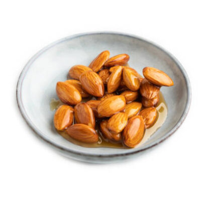 Almonds with honey isolated on white background. side view, close up.