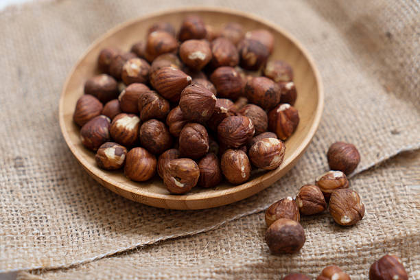 Bowl full of peeled hazelnuts on burlap sack